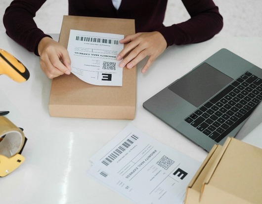 Girl attaching a shipping label on a shipping box