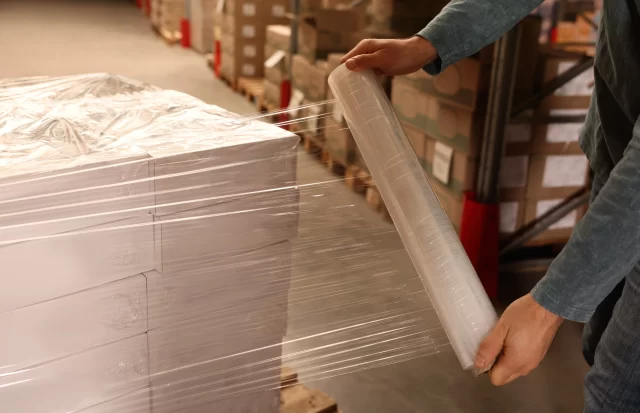 A person using Custom Printed Stretch Film for boxes packaging.