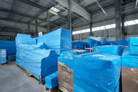 Stack of industrial packaging containers stored in a warehouse, ready for shipping and distribution.