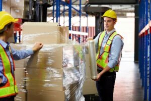 2 people using industrial shipping crates for packaging.