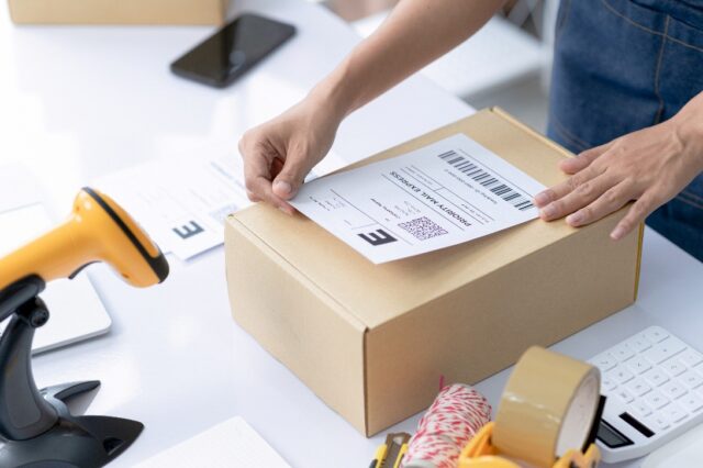 Person Placing a shipping label on shipping box